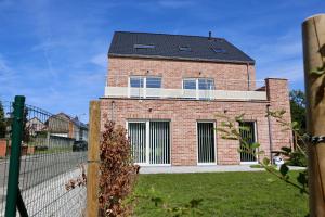 a red brick house with a black roof at BeCosy appartement 2 chambres et jardin 6 pers in Mons
