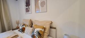 a couch with pillows on it in a room at NAVIA Mira - Design Apartment - Ruhig, Modern & Gemütlich in Dernbach