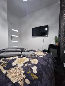 MAGIC HOME Apartamenty في رودا شلاسكا: غرفة نوم مع سرير وبطانية تشبه الورد