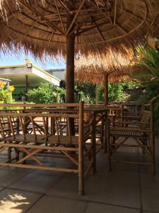 una mesa de madera y sillas bajo una sombrilla de paja en Anantra Pattaya Resort, en Pattaya central