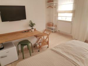 sypialnia z biurkiem i telewizorem na ścianie w obiekcie Motyl Apartamenty Studio w Bytomiu