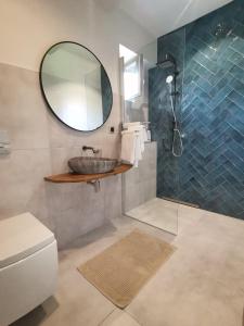 ein Bad mit einem Waschbecken und einem Spiegel in der Unterkunft Motyl Apartamenty Studio in Bytom
