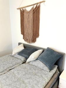 a bed with pillows and a curtain hanging above it at Seaside Apartment in Helsinki