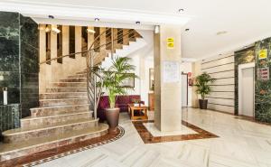 a lobby with stairs and potted plants at Globales Condes de Alcudia in Port d'Alcudia