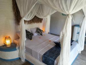 a bedroom with a bed with a canopy at SHAYA cottage in Sekotong