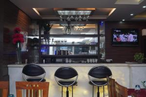 a bar with black stools in a restaurant at Hotel DH in Dharamshala
