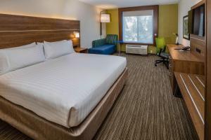 una camera d'albergo con un grande letto e una scrivania di Holiday Inn Express Hotel & Suites Modesto-Salida, an IHG Hotel a Modesto