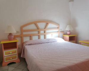 a bedroom with a large bed and two night stands at Seaside Apartment Baja Sardinia - 6pl August - 250 m from smeraldo beach in Baja Sardinia