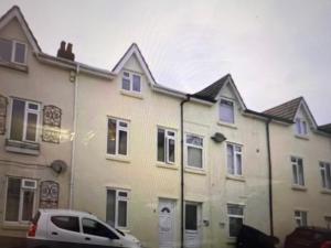 a white house with a car parked in front of it at TownHouse near Beach Bournemouth in Bournemouth