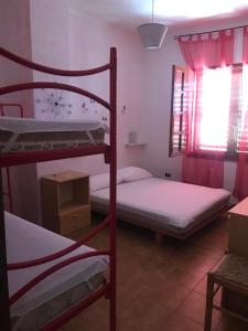 1 Schlafzimmer mit 2 Etagenbetten und einem Fenster in der Unterkunft La casa dei nonni in Talavà