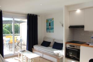 uma pequena sala de estar com um sofá na cozinha em Appartement de standing avec Piscine em La Baule