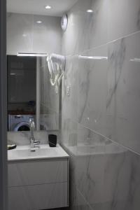 a bathroom with a sink and a shower and a mirror at Appartement de standing avec Piscine in La Baule