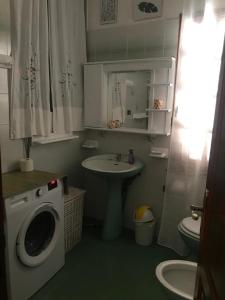 ein Badezimmer mit einer Waschmaschine und einem Waschbecken in der Unterkunft La casa dei nonni in Talavà