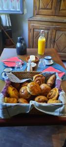 una mesa cubierta con una bandeja de bollería y zumo de naranja en L'Etape gourmande, chambres d'hôtes, en Wellin