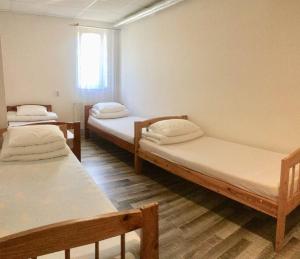 a room with three beds and a window at Harbour Hostel Tallinn in Tallinn