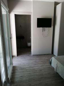 Camera con servizi igienici e TV a parete. di Suite Apartments a Cervia