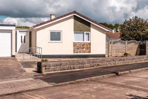 a white house with a fence in front of it at Wheelchair accessible 2 bedroom bungalow Dog Friendly in Brixham