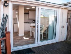 a sliding glass door leading to a kitchen with a table at Wheelchair accessible 2 bedroom bungalow Dog Friendly in Brixham