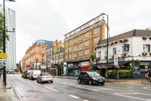 a busy city street with cars driving down a street at 2BD Stylish Home w/t Grand Piano Central London in London