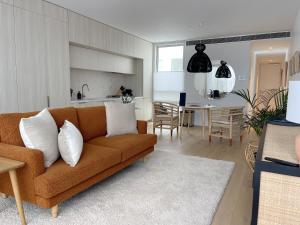 a living room with a couch and a kitchen at Oakview on Main in Mornington