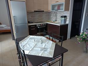 a small kitchen with a table and a refrigerator at studio apartment KAMARES in Mytilini