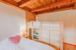 a bedroom with a white bed and a wooden ceiling at Appartement en résidence standing, ski aux pieds et garage in Montgenèvre