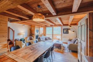 a dining room and living room with a wooden table and chairs at Appartement en résidence standing, ski aux pieds et garage in Montgenèvre