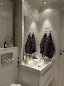 a white bathroom with a sink and a mirror at Your Lapland Sauna Stay in Rovaniemi +24 photos