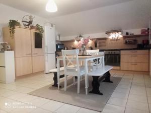 a kitchen with a white table and white chairs at Le Duplex Décontracté in Fleury-les-Aubrais