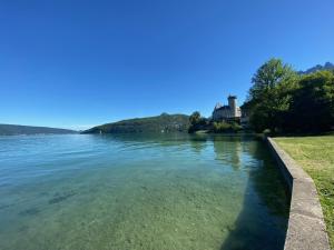 a view of a lake with a castle in the background at Duplex à 120 m du lac d'Annecy in Duingt