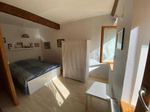 a small bedroom with a bed and a window at Duplex à 120 m du lac d'Annecy in Duingt