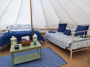 a bedroom with two beds in a tent at Rose glamping, self catering, bell tent in St Austell
