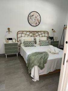 a bedroom with a large bed and a clock on the wall at Apartamentos La Chimenea in Merida