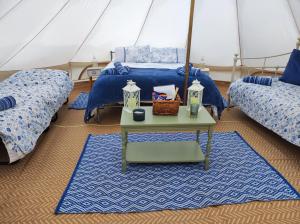 a room with two beds and a table in a tent at Rose glamping, self catering, bell tent in St Austell