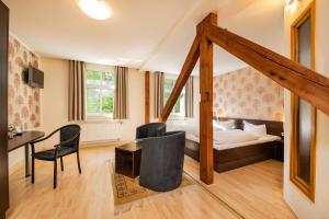 a bedroom with a bed and a desk and chairs at Kulturhotel Kaiserhof in Bad Liebenstein +78 photos