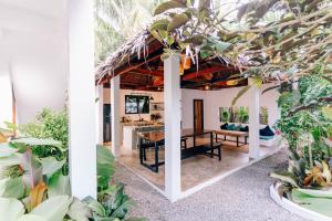 an open kitchen and dining room with a table and plants at Katmon Villas in General Luna