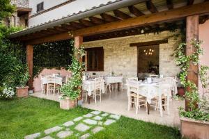 een patio met tafels en stoelen onder een pergola bij Appartamenti Poggio Fiorito in Assisi