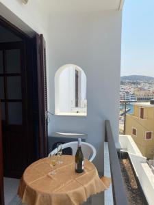 a table with two glasses of wine on a balcony at Dolphin Hotel Apartments in Karpathos