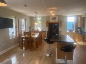kuchnia i jadalnia ze stołem i krzesłami w obiekcie Ned's Cottage w mieście Kincasslagh