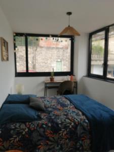 a bedroom with a bed and a desk and two windows at Apptt rénové bien situé parking terrasse vélos in Blois