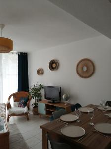 a living room with a table and a television at Apptt rénové bien situé parking terrasse vélos in Blois