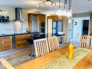 a kitchen with a wooden table and a dining room at Ned's Cottage in Kincasslagh
