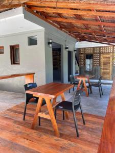 two wooden tables and chairs on a patio at M-Resort Siargao in General Luna