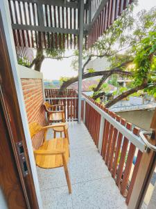 a porch with two chairs and a tree at Puu Pau Hotel & Coffee Shop in Labuan Bajo