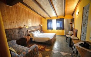 a bedroom with a bed and a couch and a chair at Agriturismo Casa delle Erbe 
