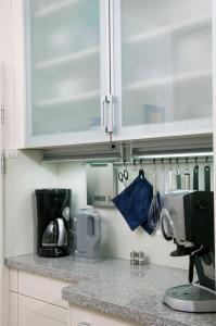 a kitchen with white cabinets and a counter top at Ferienwohnung mit Meerblick und Westbalkon in Wangerooge +3 photos