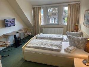 um quarto com 2 camas, uma secretária e uma janela em Studio für 2 Pers mit DU/WC em Braunlage