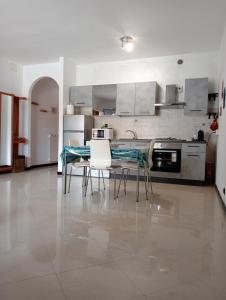 a large kitchen with a table and chairs in it at AIRPORT HOUSE MARIEl in Genoa