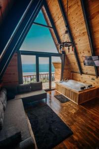 a living room with a large window and a bath tub at Rova Suit Bungalov in Rize