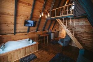 a bathroom with a tub and a tv in a cabin at Rova Suit Bungalov in Rize